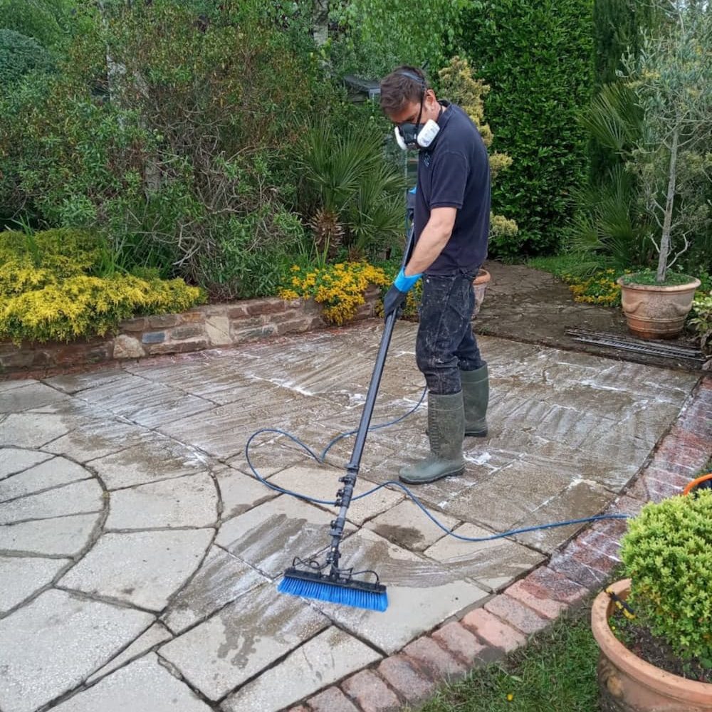 Softwashing garden patio with cleaning chemicals